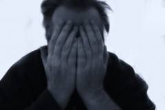 Mann verdeckt sein Gesicht mit Händen - Burnout