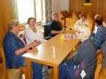 Mehrere Menschen sitzen rund um einen hölzernen Tisch: die Selbsthilfegruppe für von einem Schlaganfall-Betroffene und deren Familienangehörige in St. Pölten