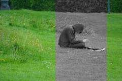 Fertiger Mann mit Kapuze im Gras