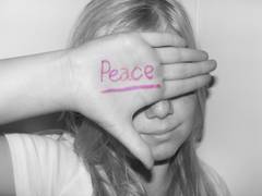 Trauriges Mädchen,auf ihrer Hand steht "Peace"