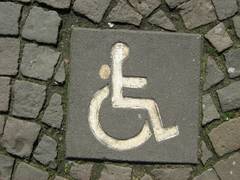 Markierung für Behindertenparkplatz: Kopfsteinpflaster mit Rollstuhlsymbol
