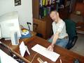 Ein Mann mit Behinderung sitzt am Schreibtisch und drückt eine Taste