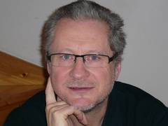 Portrait eines Mannes mit Brille und höherer Stirn mit Locken
