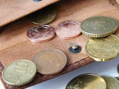 Geldtasche, aus der Euromünzen fallen