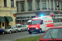 Ein Krankenwagen fährt mit Blaulicht eine Straße in Wien entlang