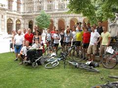 Gruppenbild im Arkadenhof mit Rollstuhlfahrerin und Radfahrern