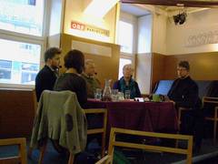Vier Personen sitzen auf einem Podium im RadioCafe und diskutieren