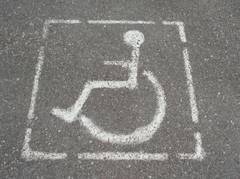 Rollstuhlzeichen auf grauem Beton