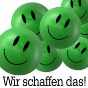 Grüne 3-D-Smileys mit Text "Wir schaffen das!"